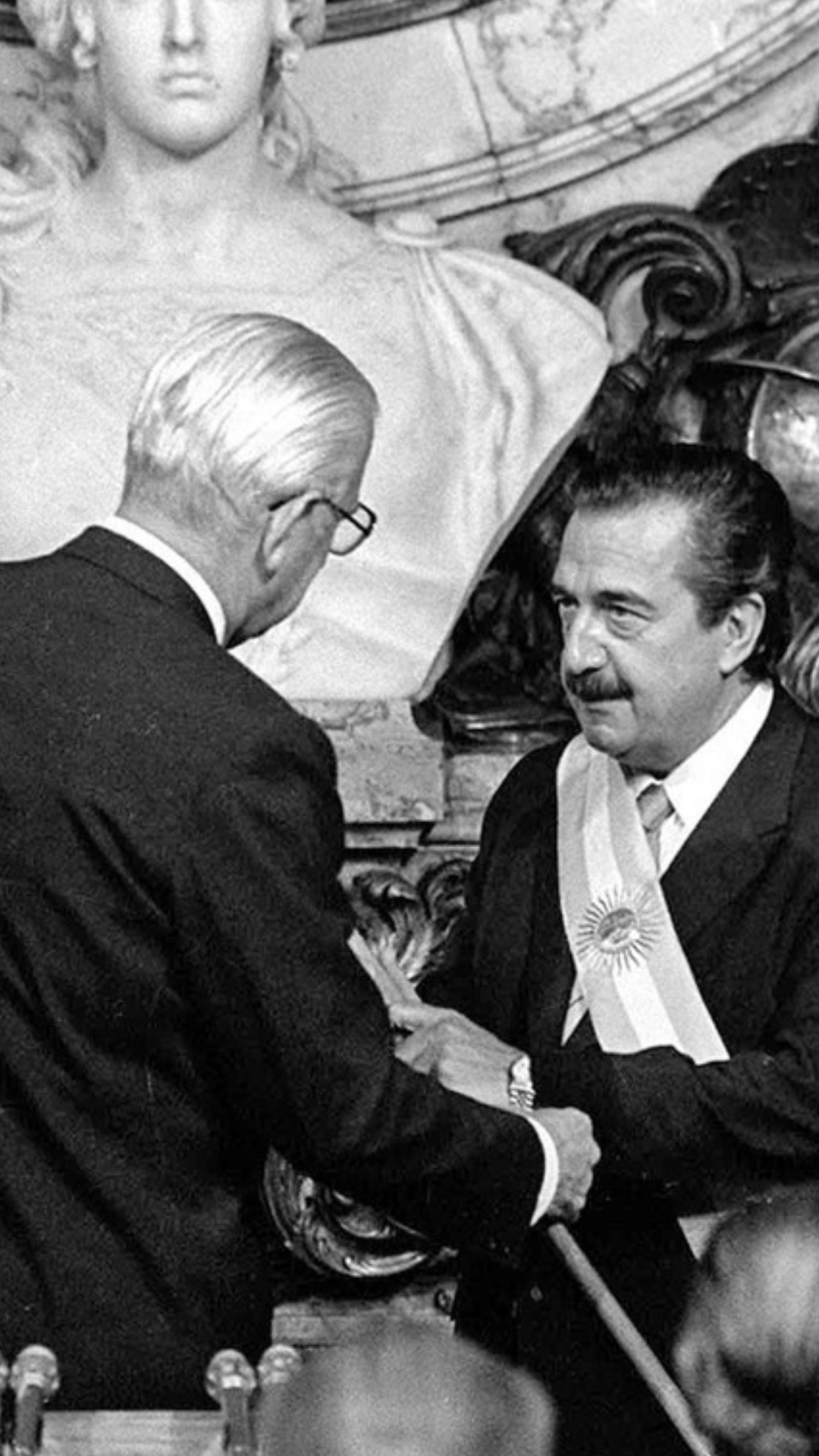 Raúl Alfonsín recibe la banda y el bastón presidencial del último presidente de facto, Reynaldo Bignone.
