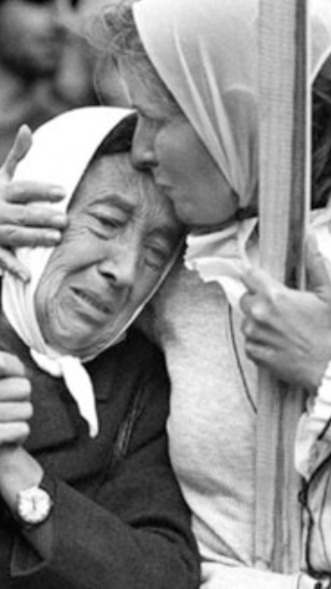 Abuela de plaza de mayo durante el juicio,emocionada, mientras otra la abraza y besa en la frente.