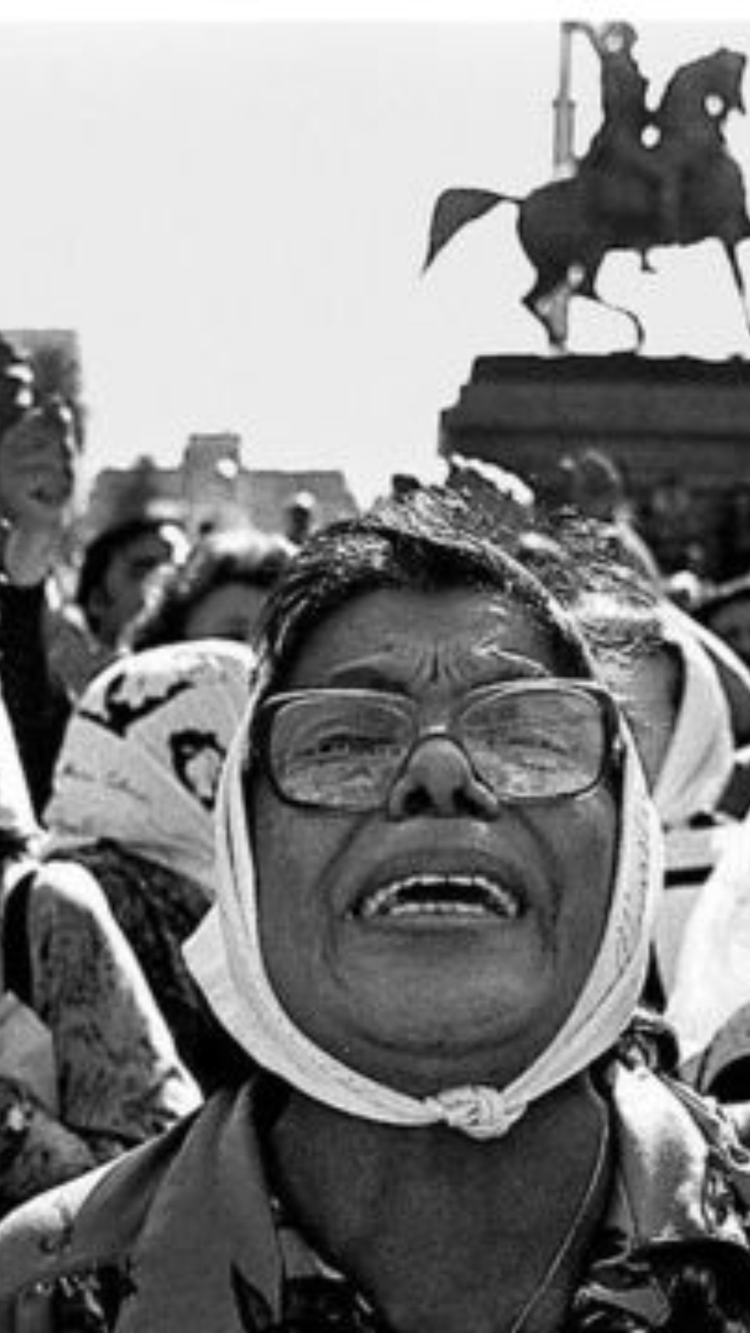 Madres de plaza de mayo, en la calle, escuchando el juicio y pidiendo justicia. En primer plano una madre grita emocionada.