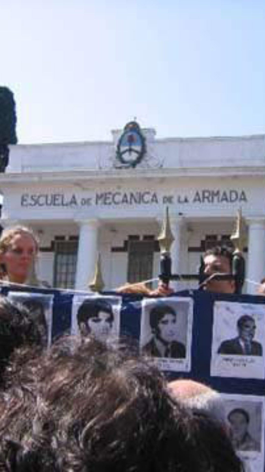 Entrada de la EX Esma el 24 de marzo de 2004. Sobre la reja un afiche con fotos de desaparecidos.